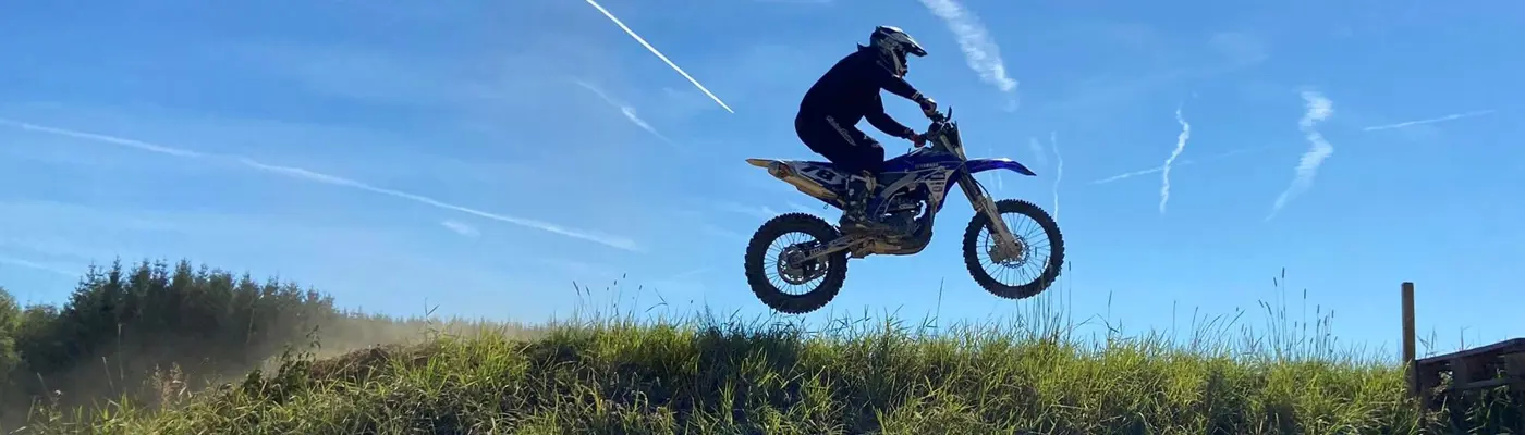 Motocross Motorrad beim Springen mit blauen Himmel