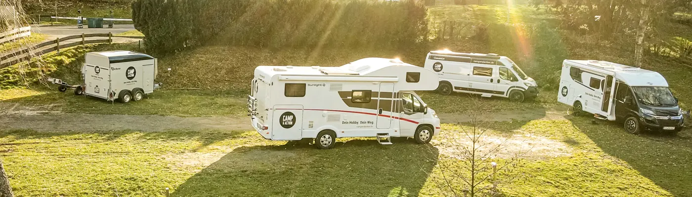 Drohnen-Aufnahme von der Seite mit den Camp and Action Fahrzeugen und Sonnenstrahlen