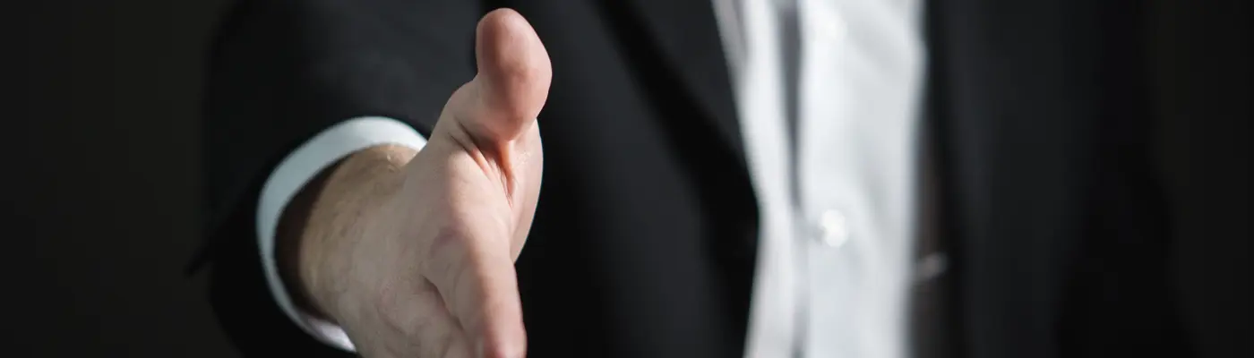 Mann reicht die Hand in Richtung der Betrachters 