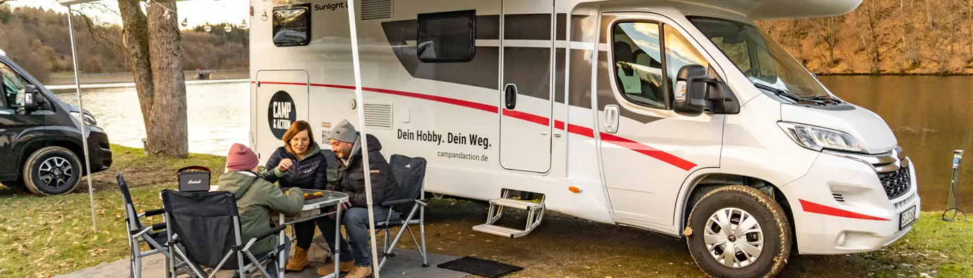 Familie am Tisch sitzend unter Markise Wohnmobil_Sunlight A70